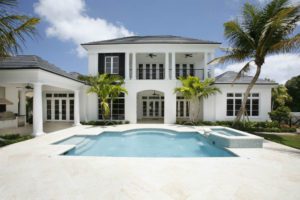 A large white house with a pool in the middle of it.