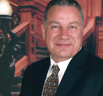 A man in suit and tie standing next to stairs.